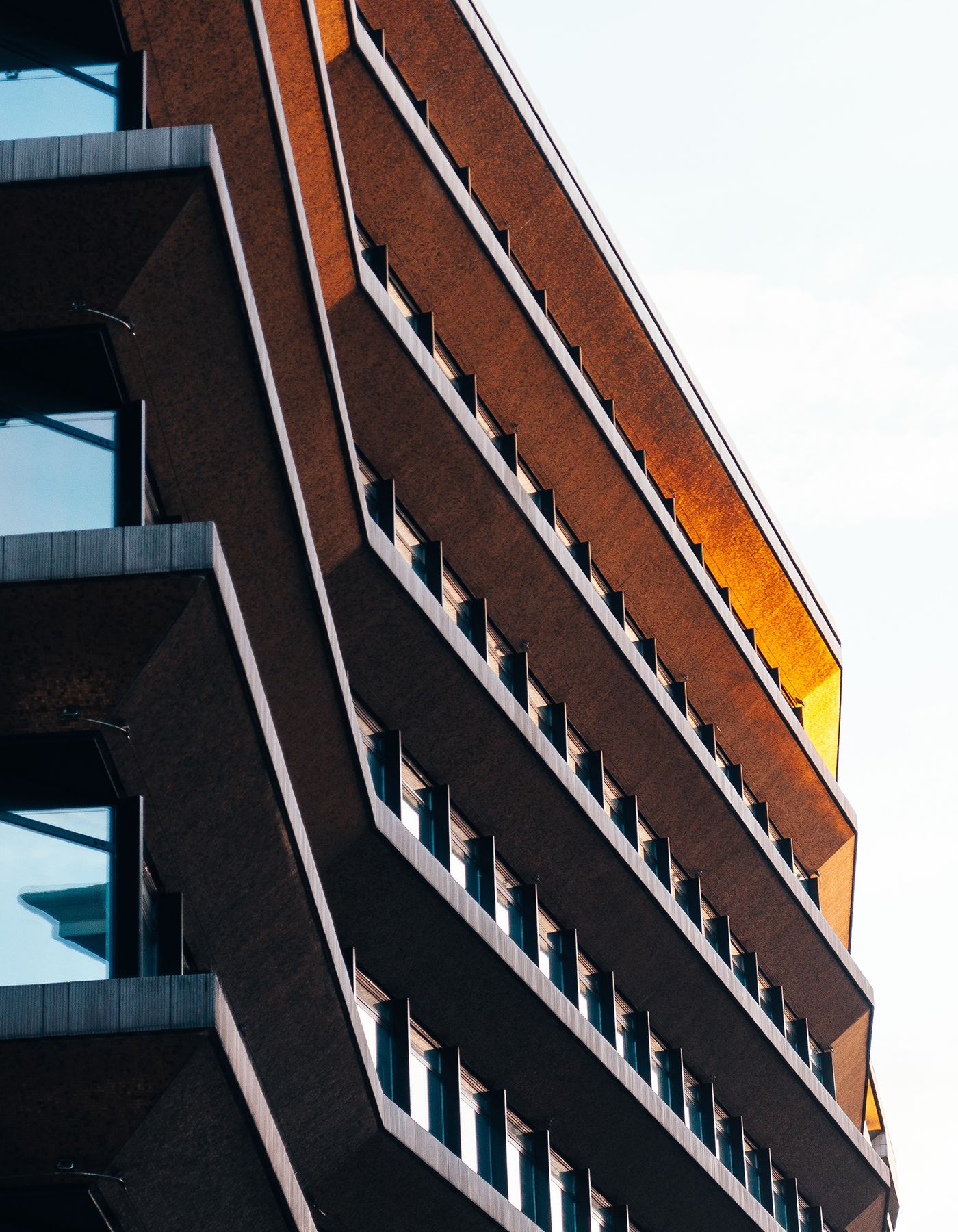 Modernt flervåningshus i rött tegel med balkonger