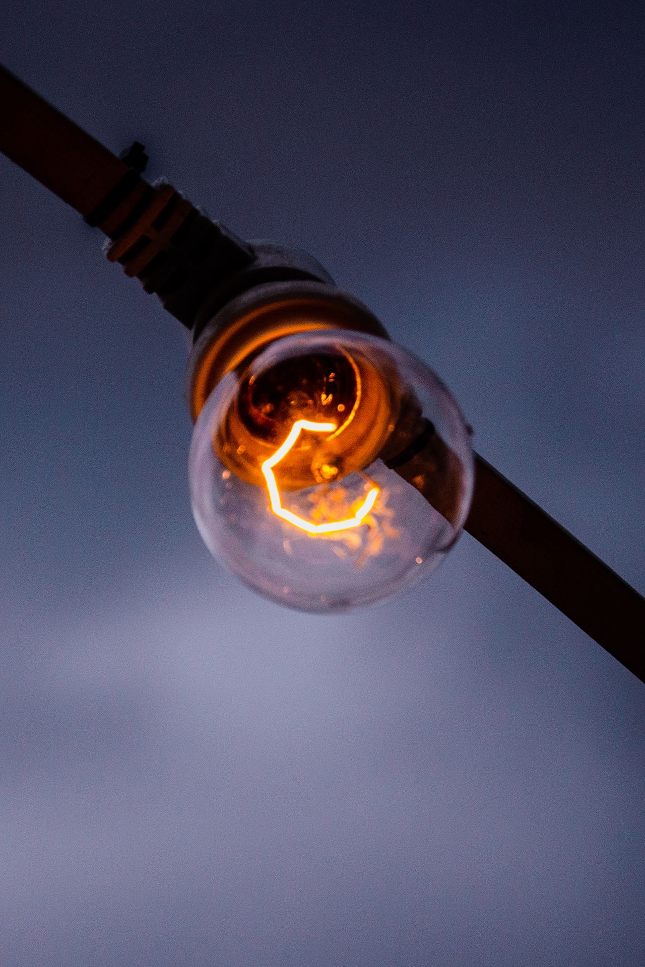 Glödlampa som lyser mot kvällshimmel
