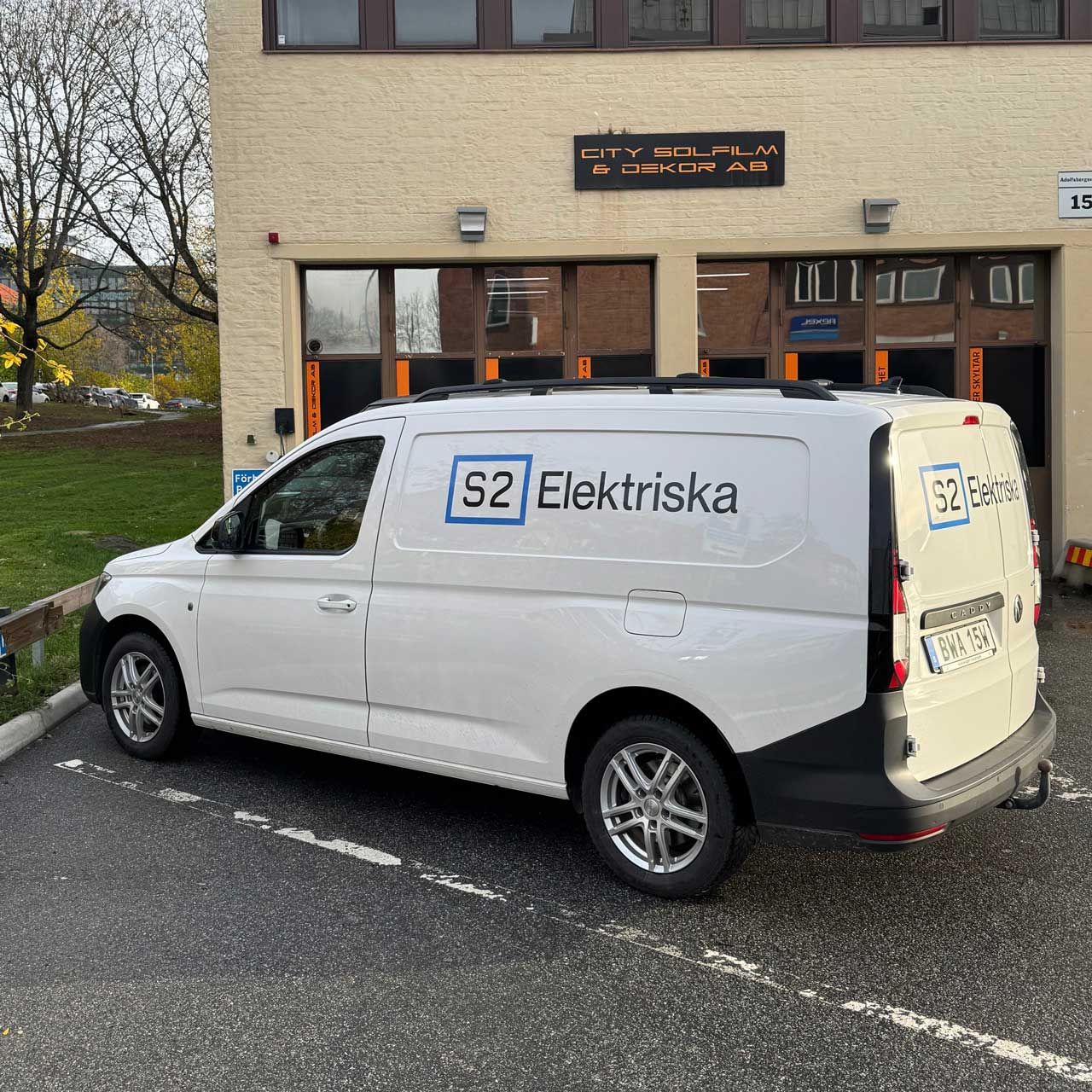 S2 Elektriska firmabil med logotypdekal parkerad utanför lokaler