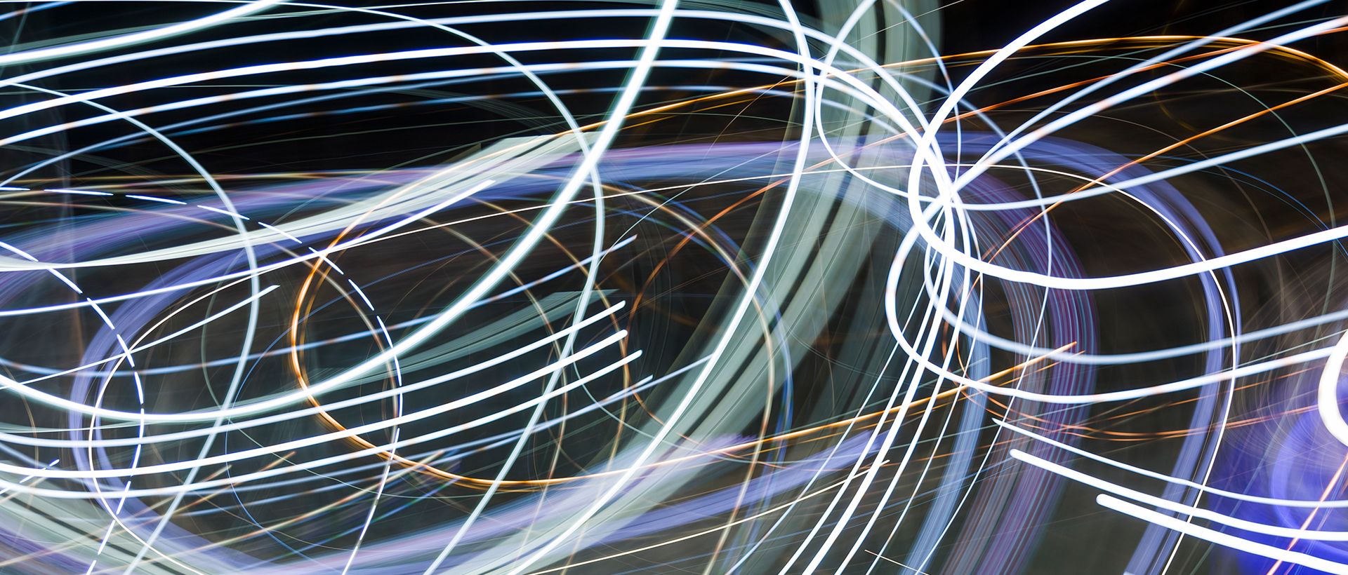 Abstrakta ljusspår i blå och orange färger mot mörk bakgrund