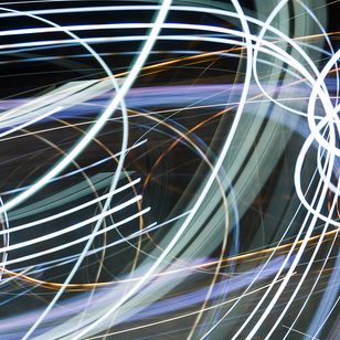 Abstrakta ljusspår i blå och orange färger mot mörk bakgrund