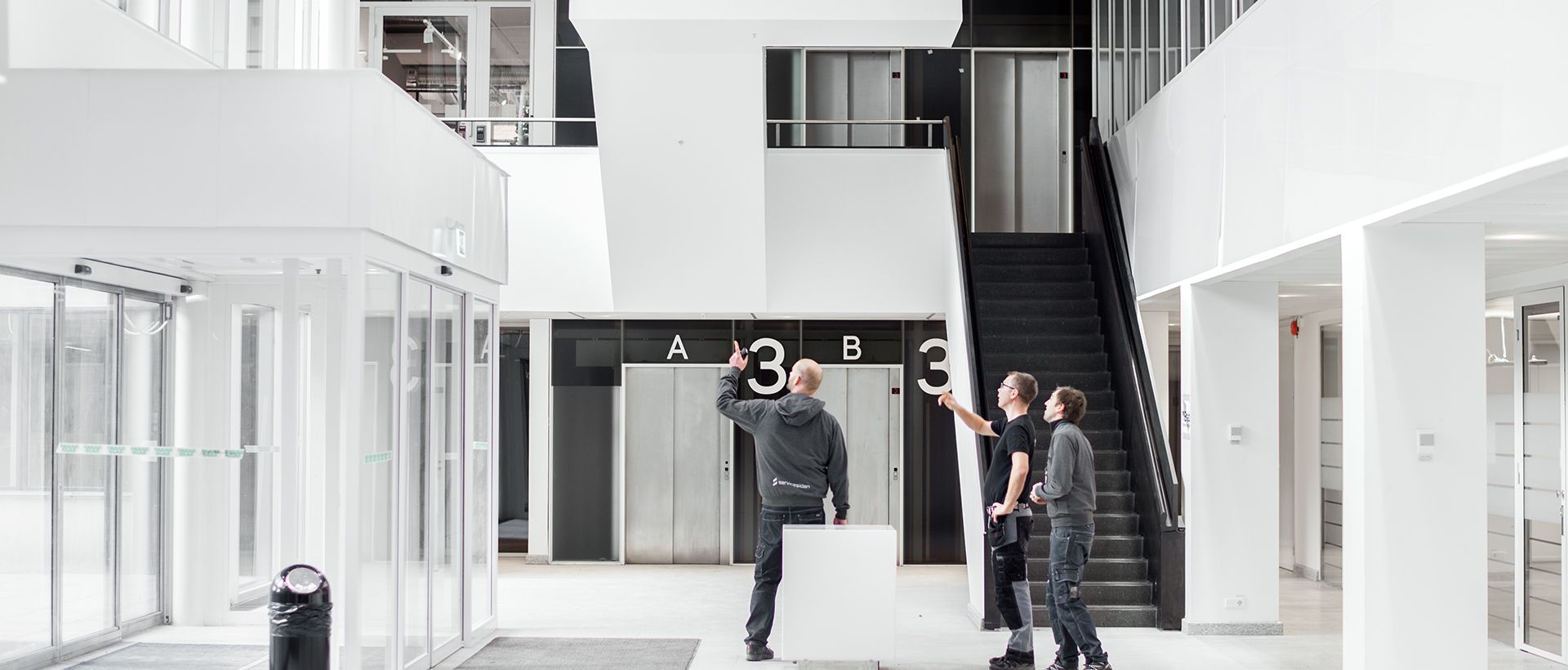 Tre S2 Elektriska-medarbetare på hustak med stadsvy