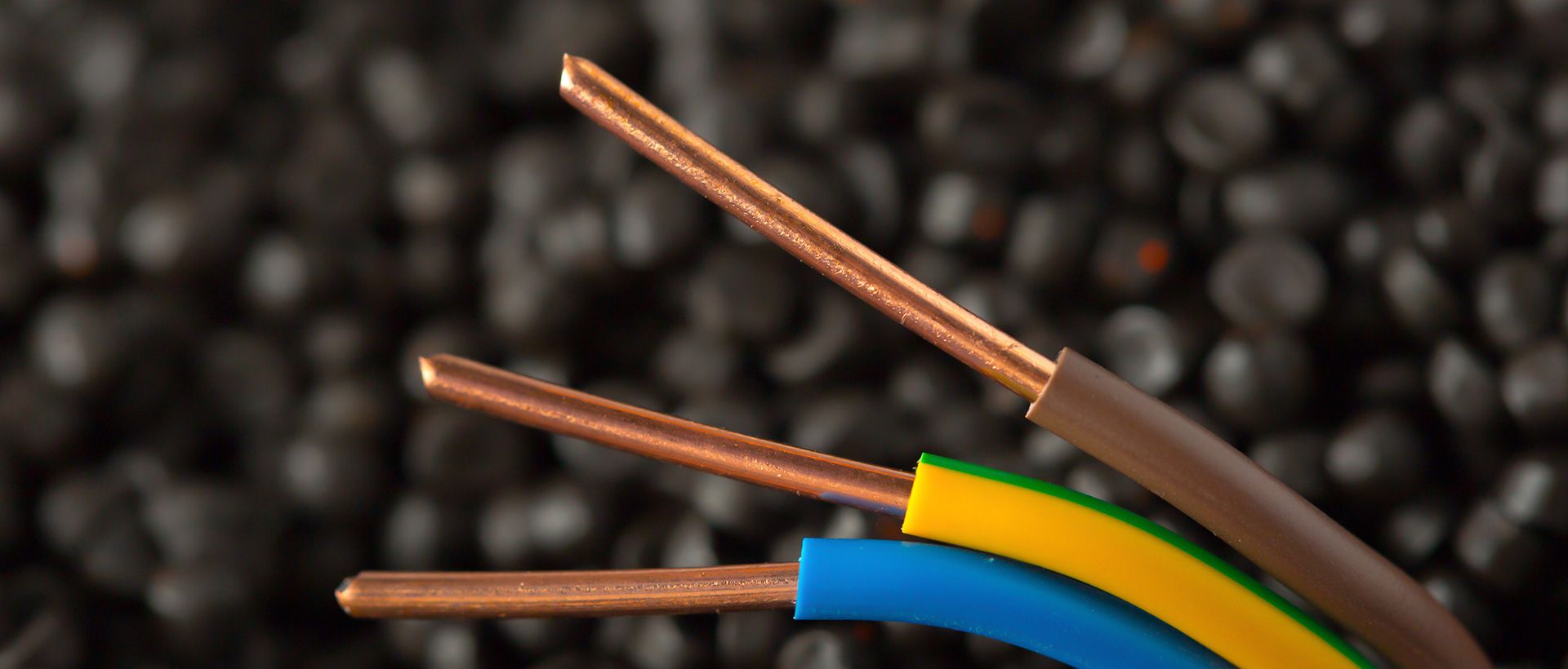 Närbild på avskalade kopparkablar mot mörk bakgrund